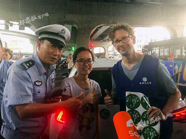 交警谭乔现场执法 老外江喃成文明劝导员为礼让行人点赞